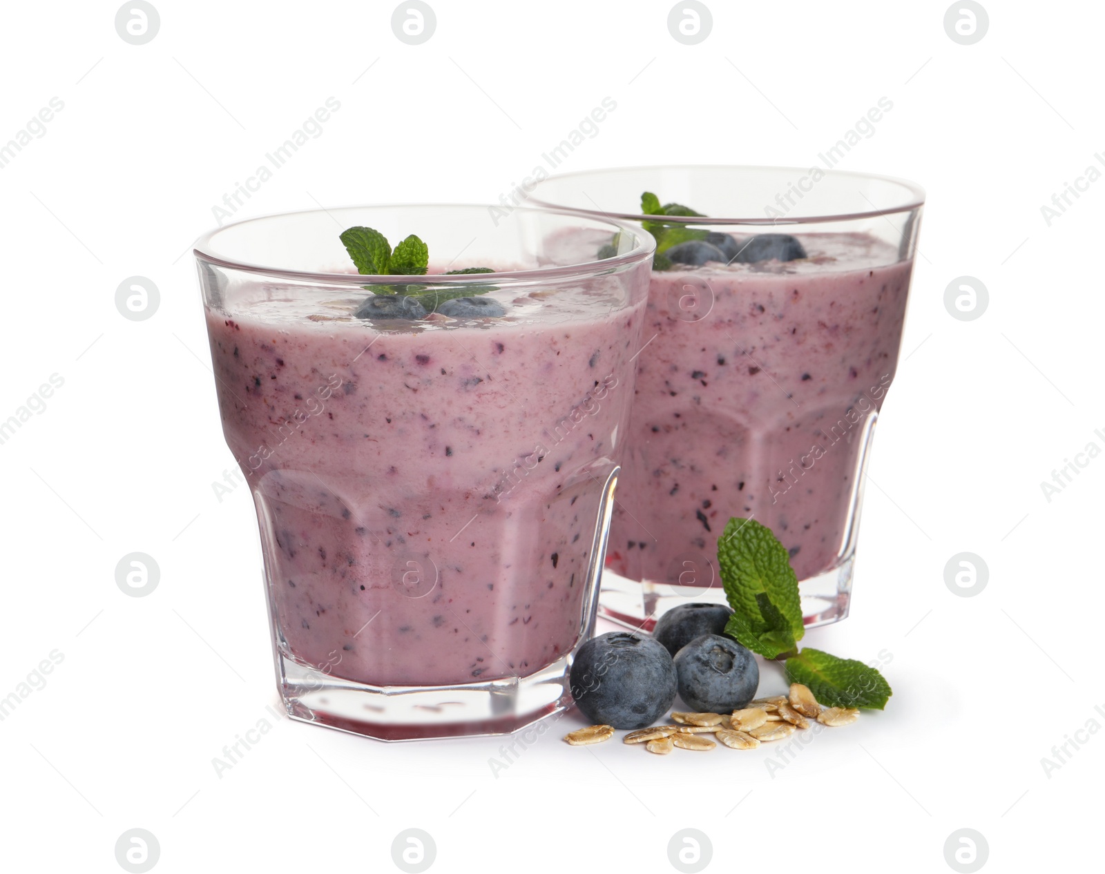 Photo of Tasty blueberry smoothie with oatmeal in glasses on white background