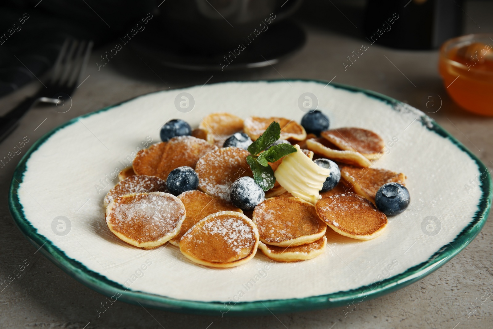 Photo of Cereal pancakes with blueberries and butter on grey table