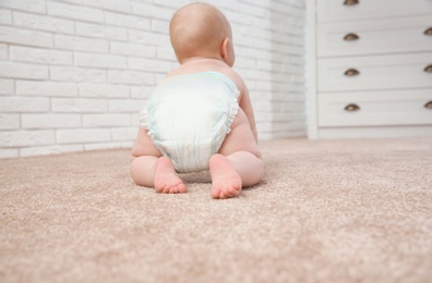 Photo of Cute little baby crawling on carpet indoors