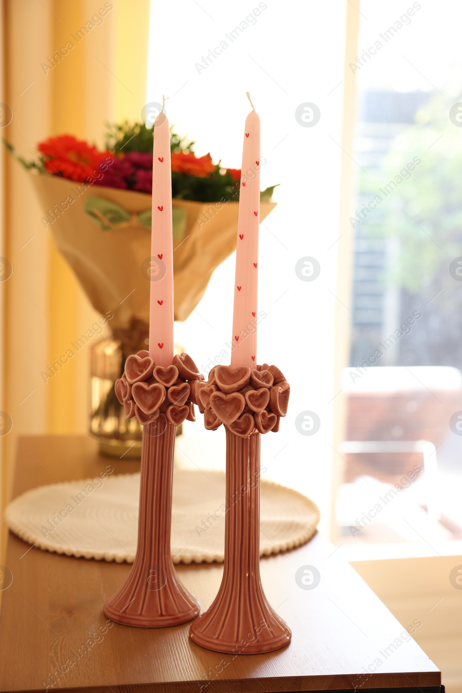 Photo of Bouquet of flowers and candles on wooden table indoors, selective focus