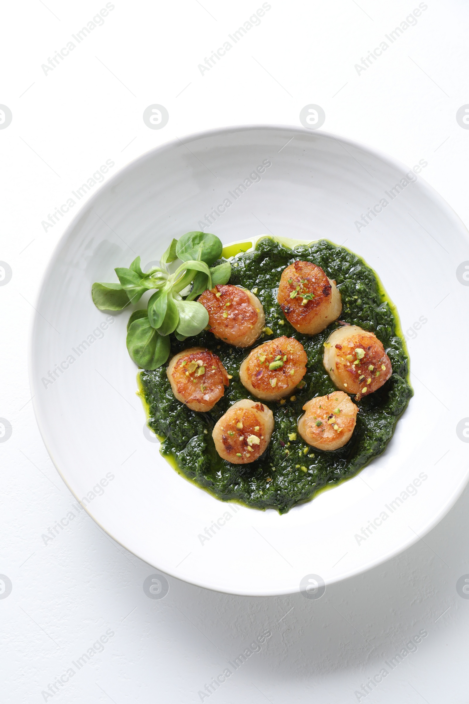 Photo of Delicious fried scallops with tasty sauce and corn salad in bowl on white background, top view