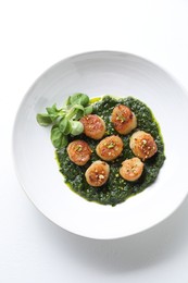 Delicious fried scallops with tasty sauce and corn salad in bowl on white background, top view