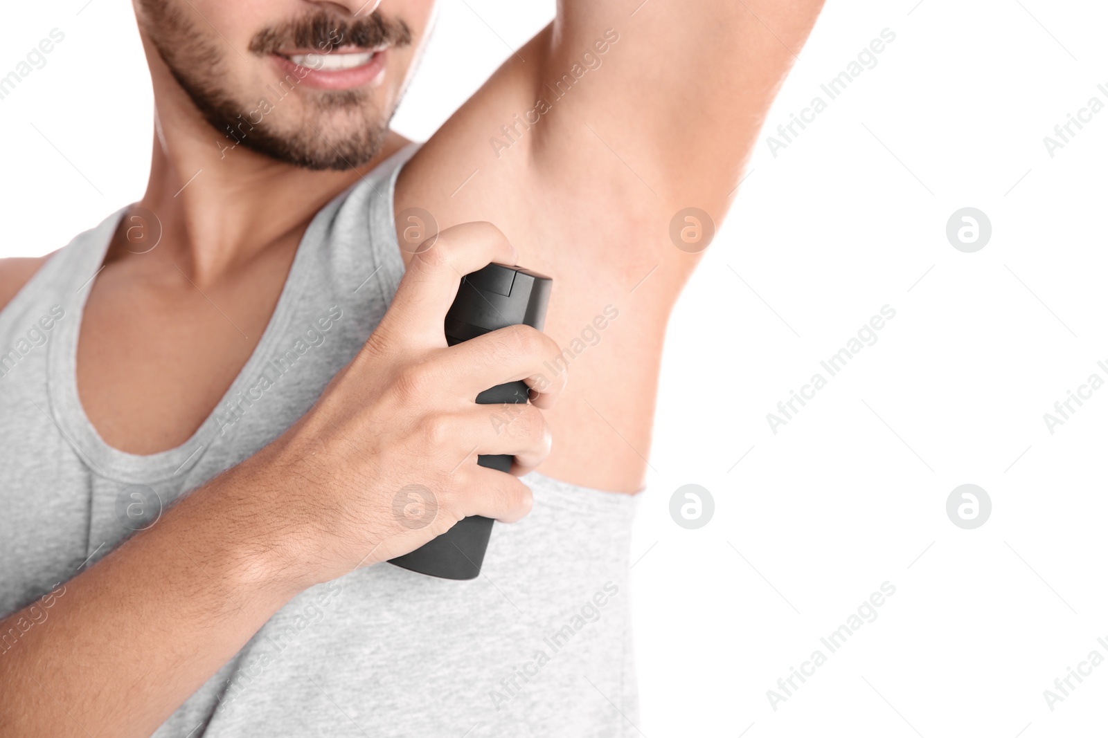 Photo of Young man using deodorant on white background, closeup