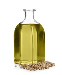 Bottle with hemp oil and seeds on white background