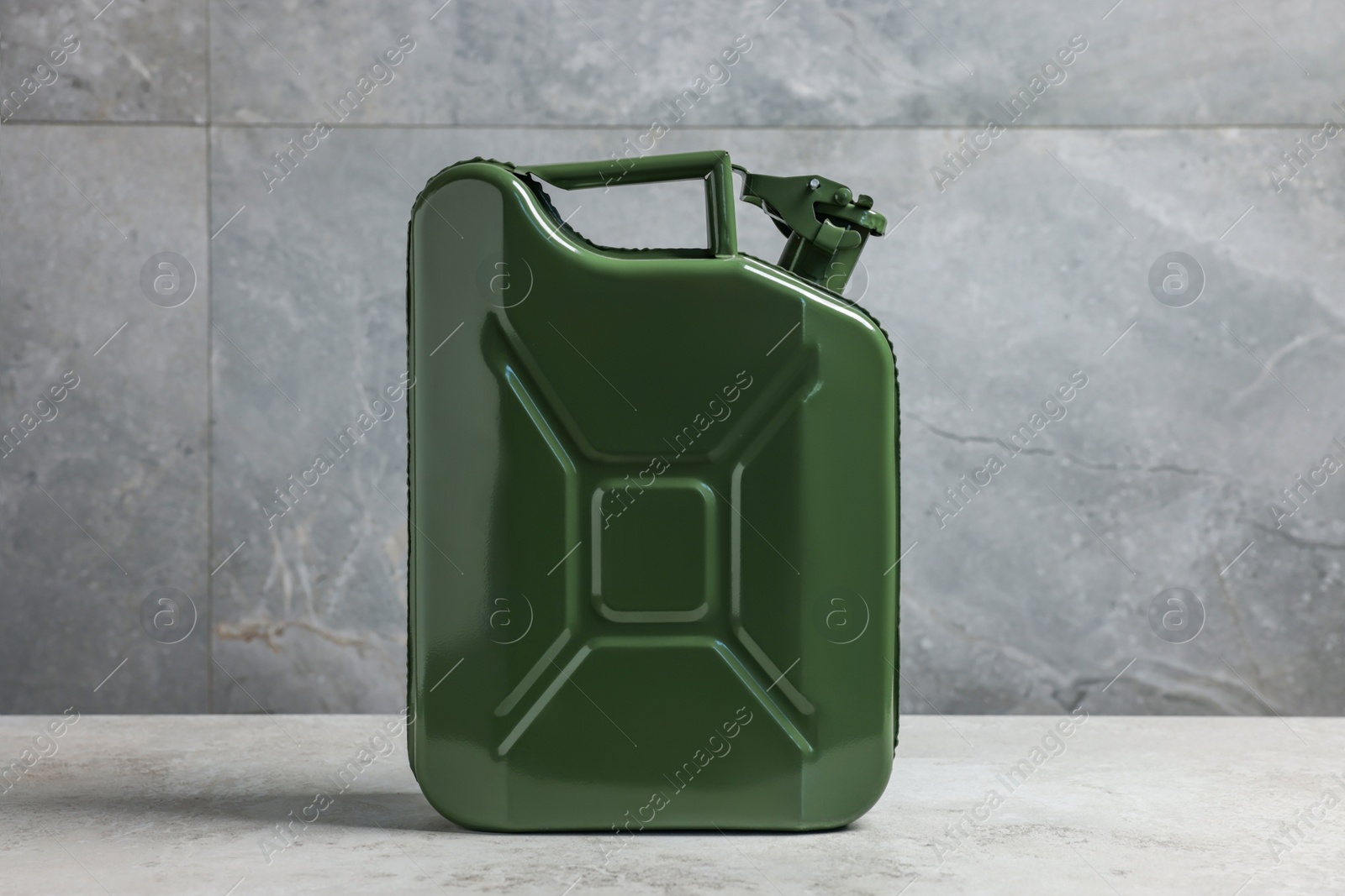 Photo of New khaki metal canister on floor near light grey wall