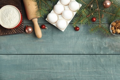Photo of Flat lay composition with ingredients for traditional Christmas cake on blue wooden table. Space for text
