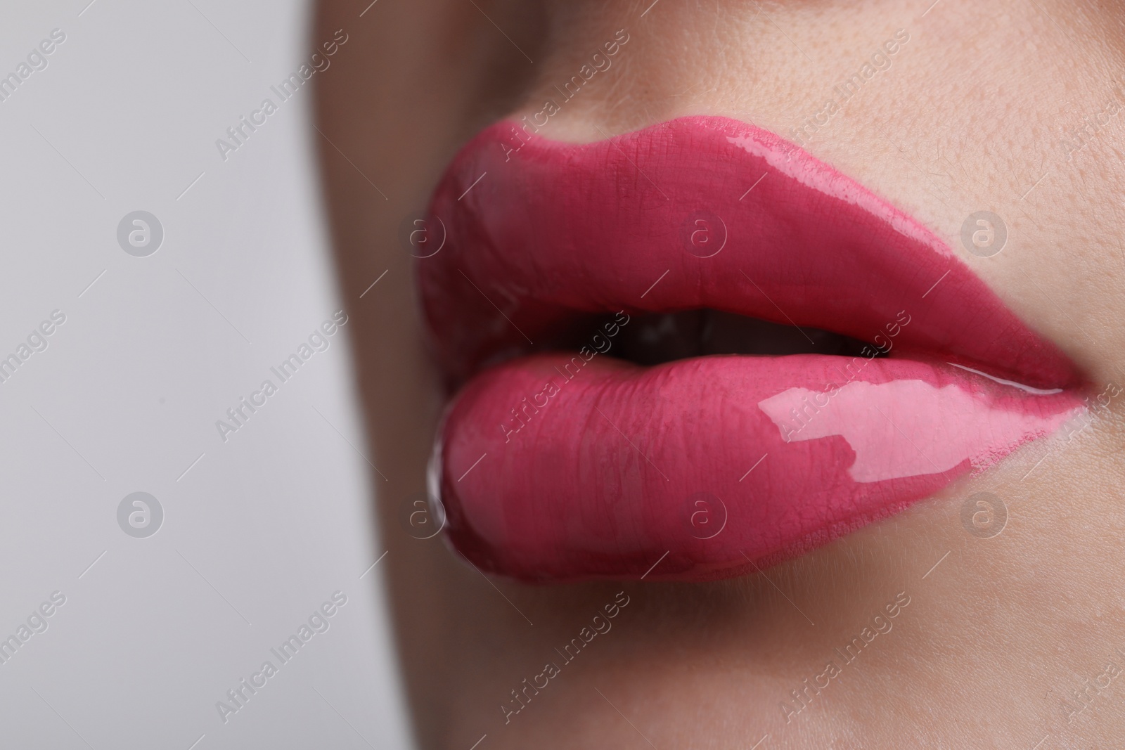 Photo of Closeup view of beautiful young woman with perfect lips makeup on light grey background