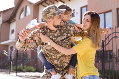 Male soldier reunited with his family outdoors. Military service