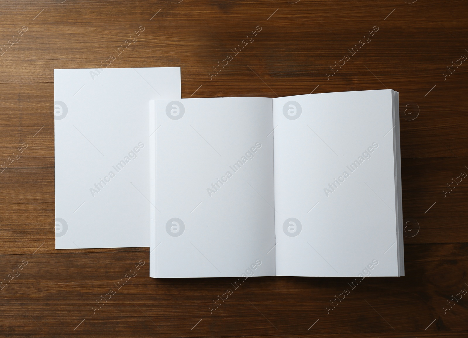 Photo of Sheet of paper and blank brochure on wooden table, flat lay. Mockup for design