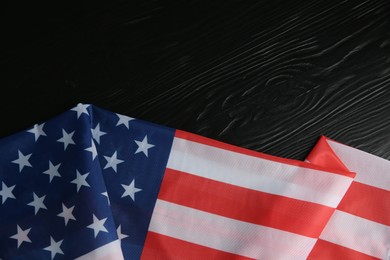 Photo of Flag of USA on black wooden table, top view. Space for text