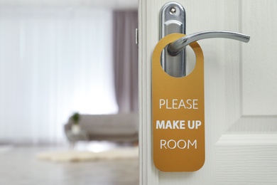 Photo of Open door with sign PLEASE MAKE UP ROOM on handle at hotel, space for text