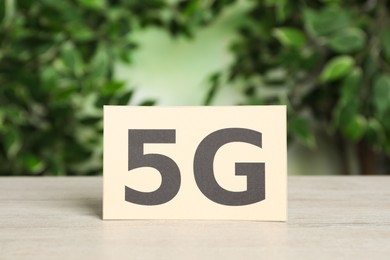 Photo of 5G technology, Internet concept. Card on white wooden table