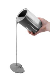 Photo of Woman pouring grey paint from can on white background, closeup