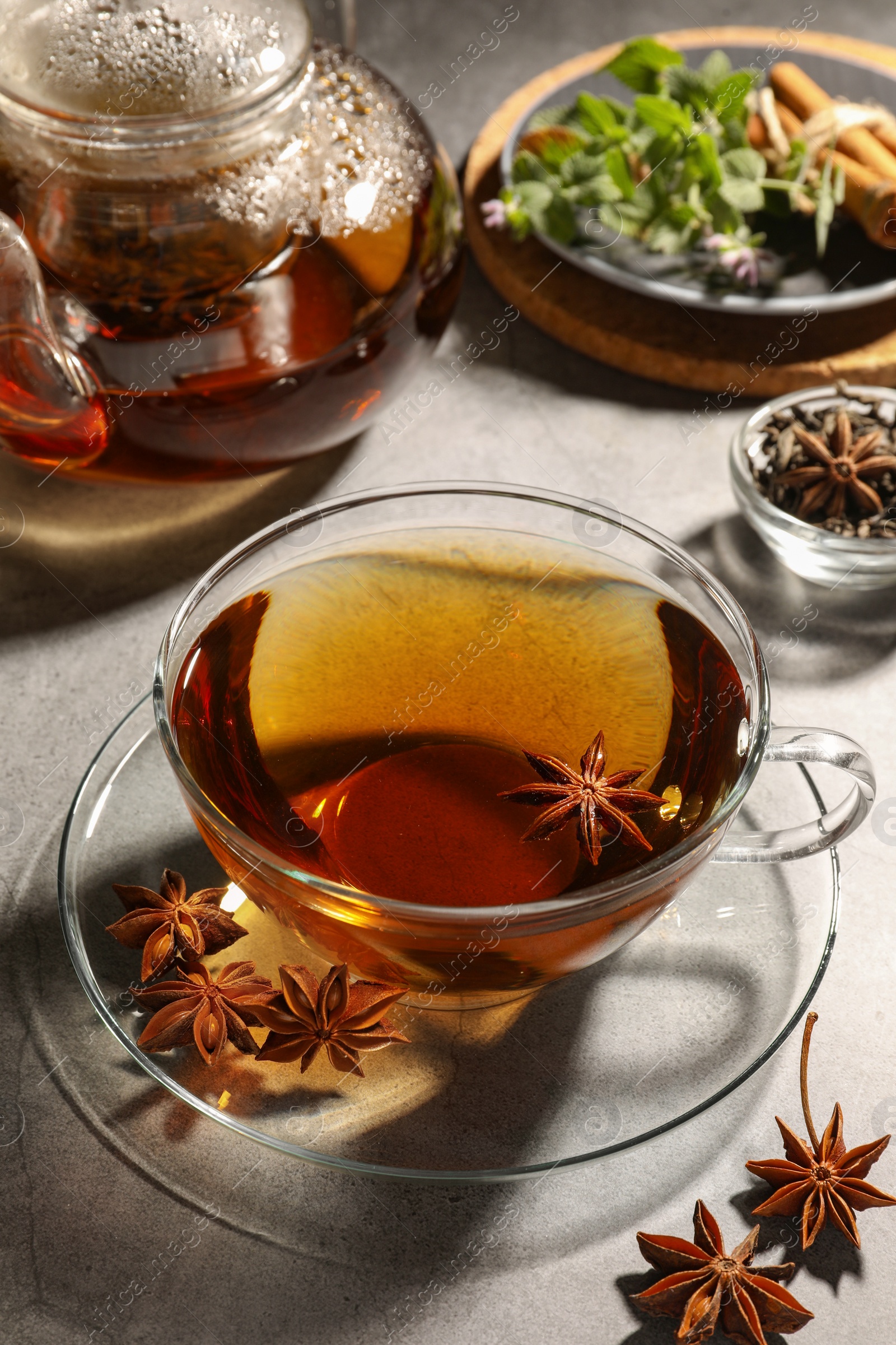 Photo of Aromatic tea with anise stars on light grey table