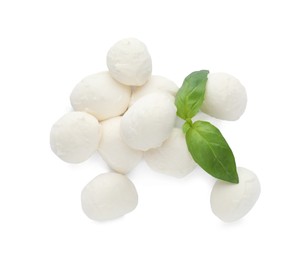 Pile of mozzarella cheese balls and basil on white background, top view