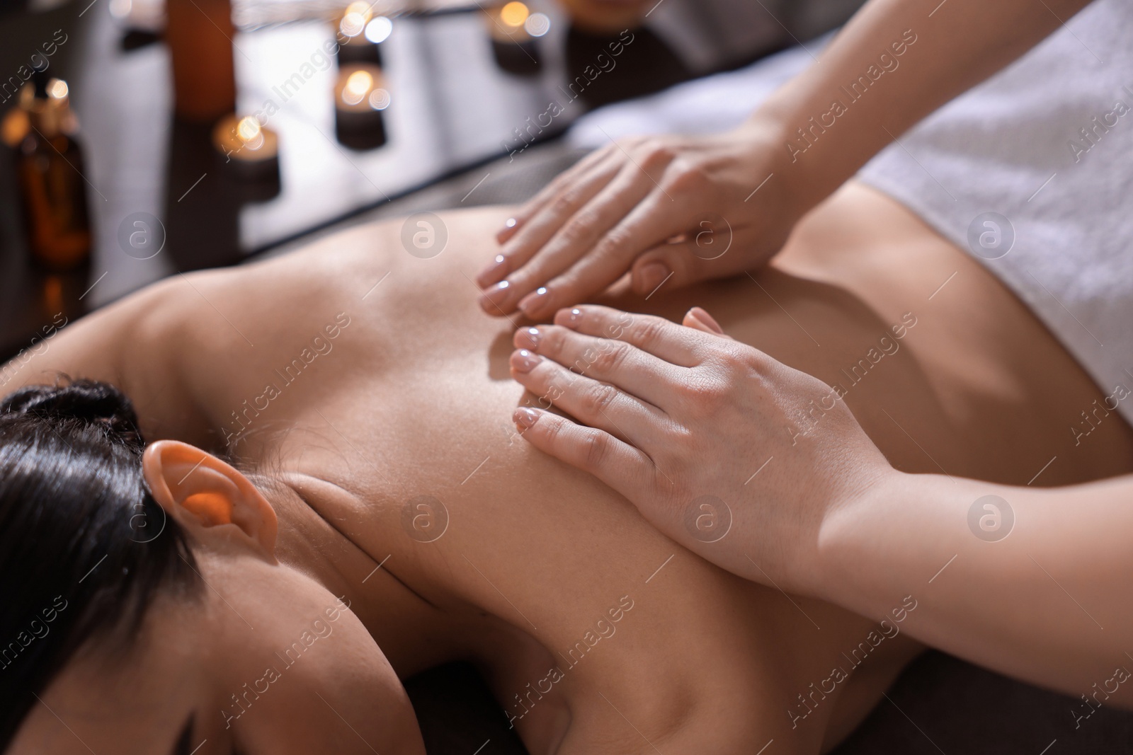 Photo of Spa therapy. Beautiful young woman lying on table during massage in salon, closeup