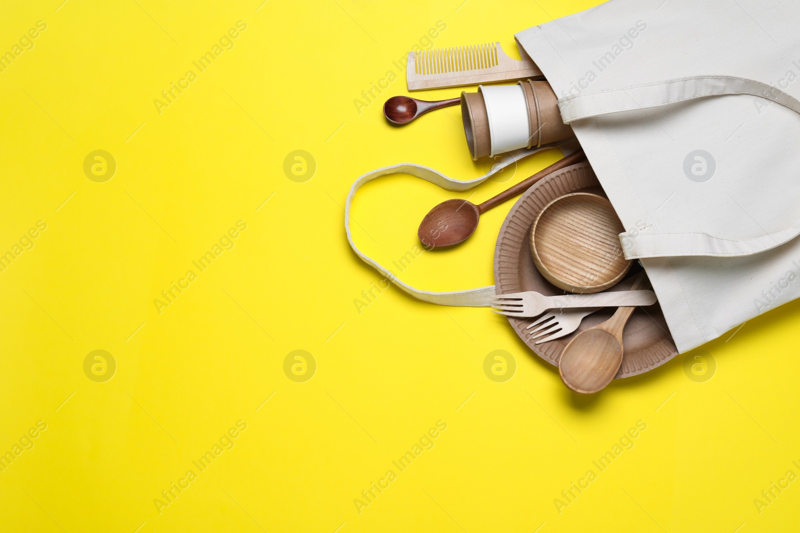 Photo of Eco bag with different disposable items on yellow background, top view and space for text. Recycling concept