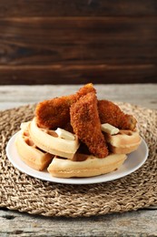 Delicious Belgium waffles served with fried chicken and butter on wooden table, closeup. Space for text