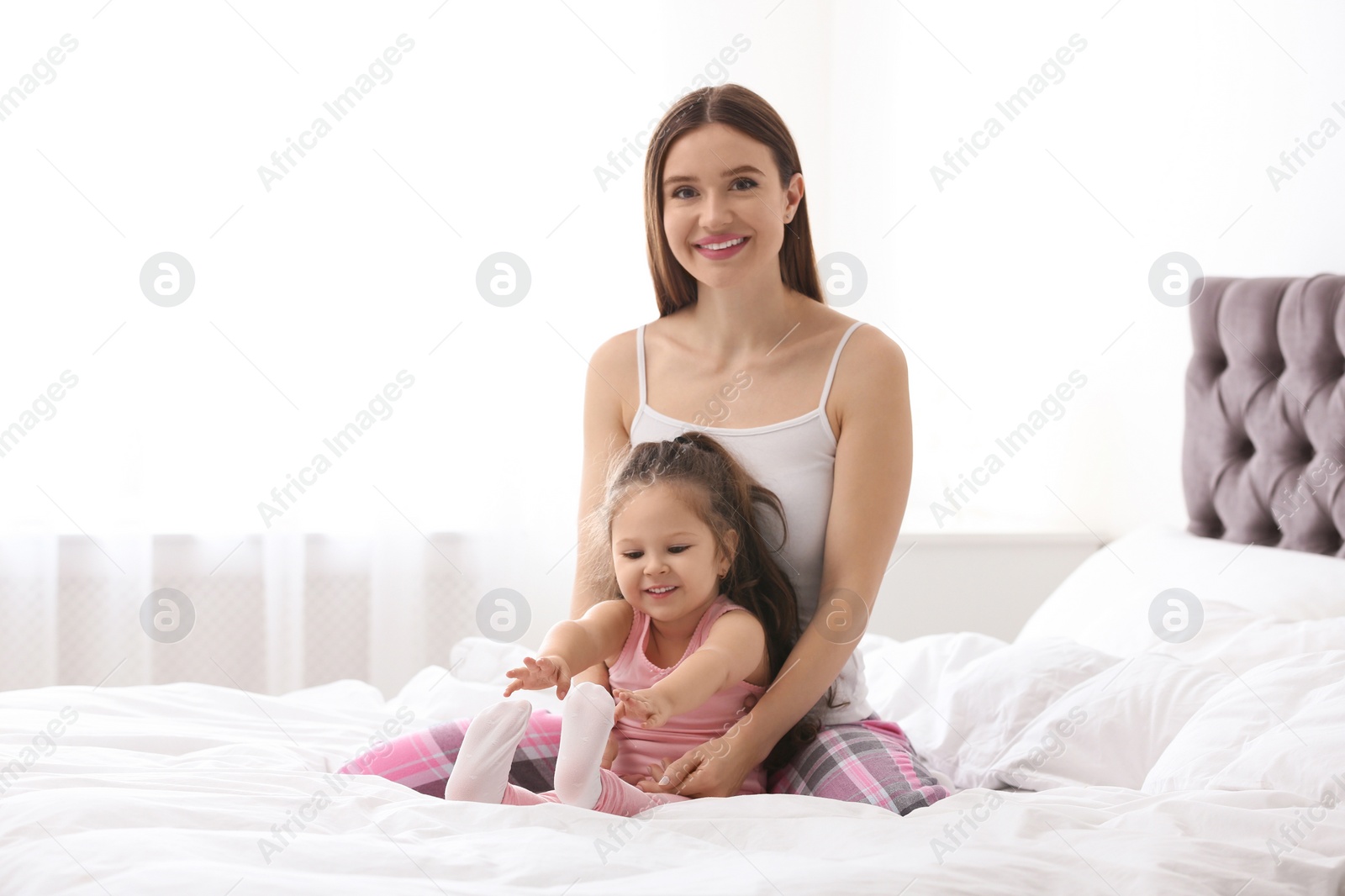 Photo of Happy mother with little daughter in bedroom