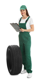 Professional auto mechanic with tire and clipboard on white background