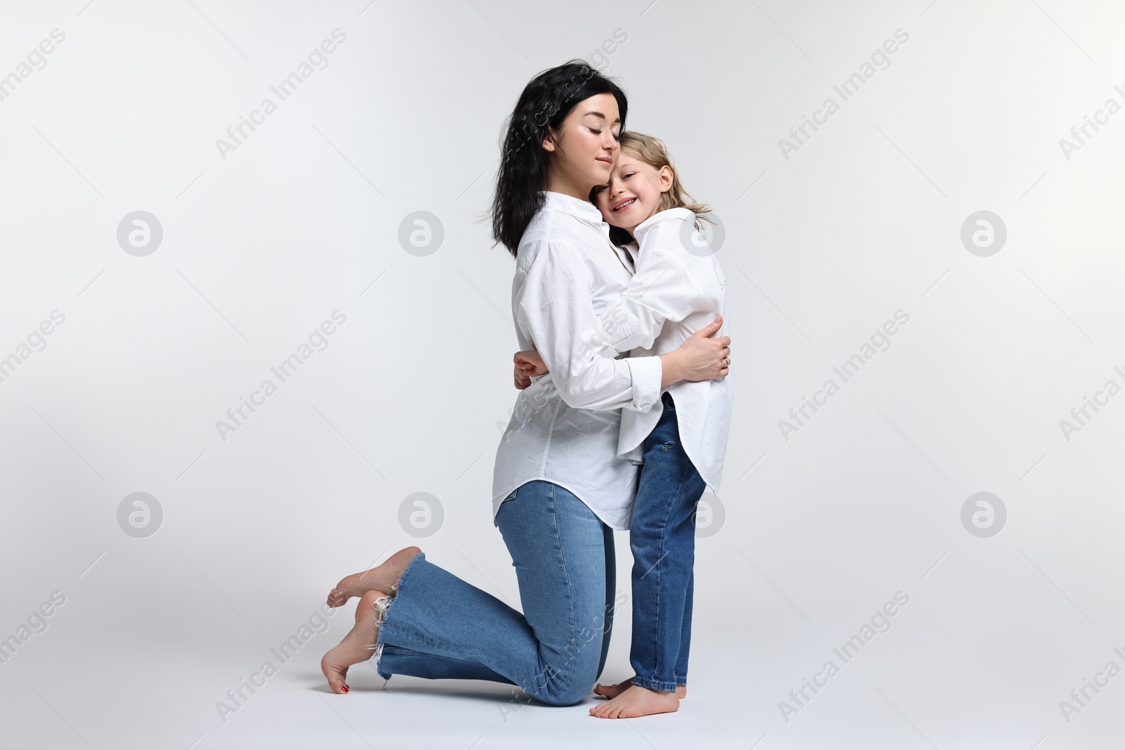 Photo of Beautiful mother with little daughter on white background