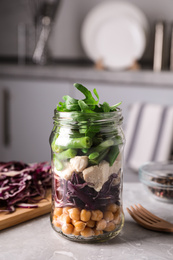 Photo of Glass jar with healthy meal on light grey marble table