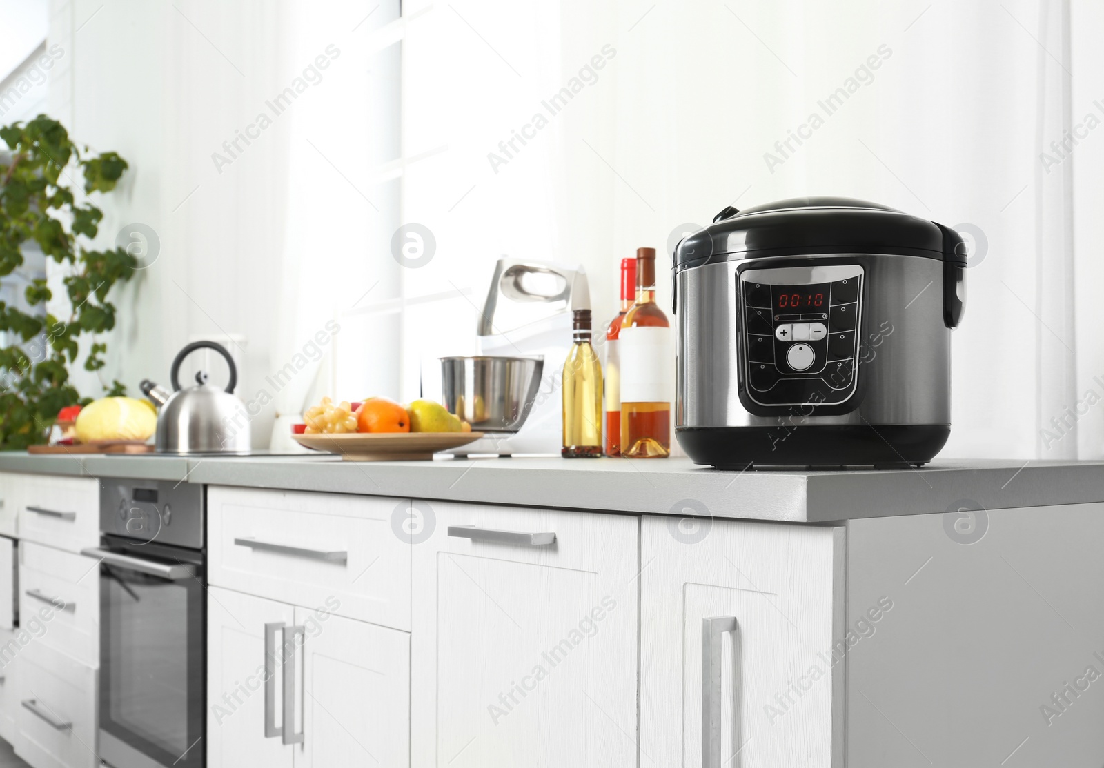 Photo of Modern multi cooker and products on table in kitchen. Space for text