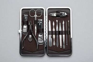 Manicure set in case on grey background, top view