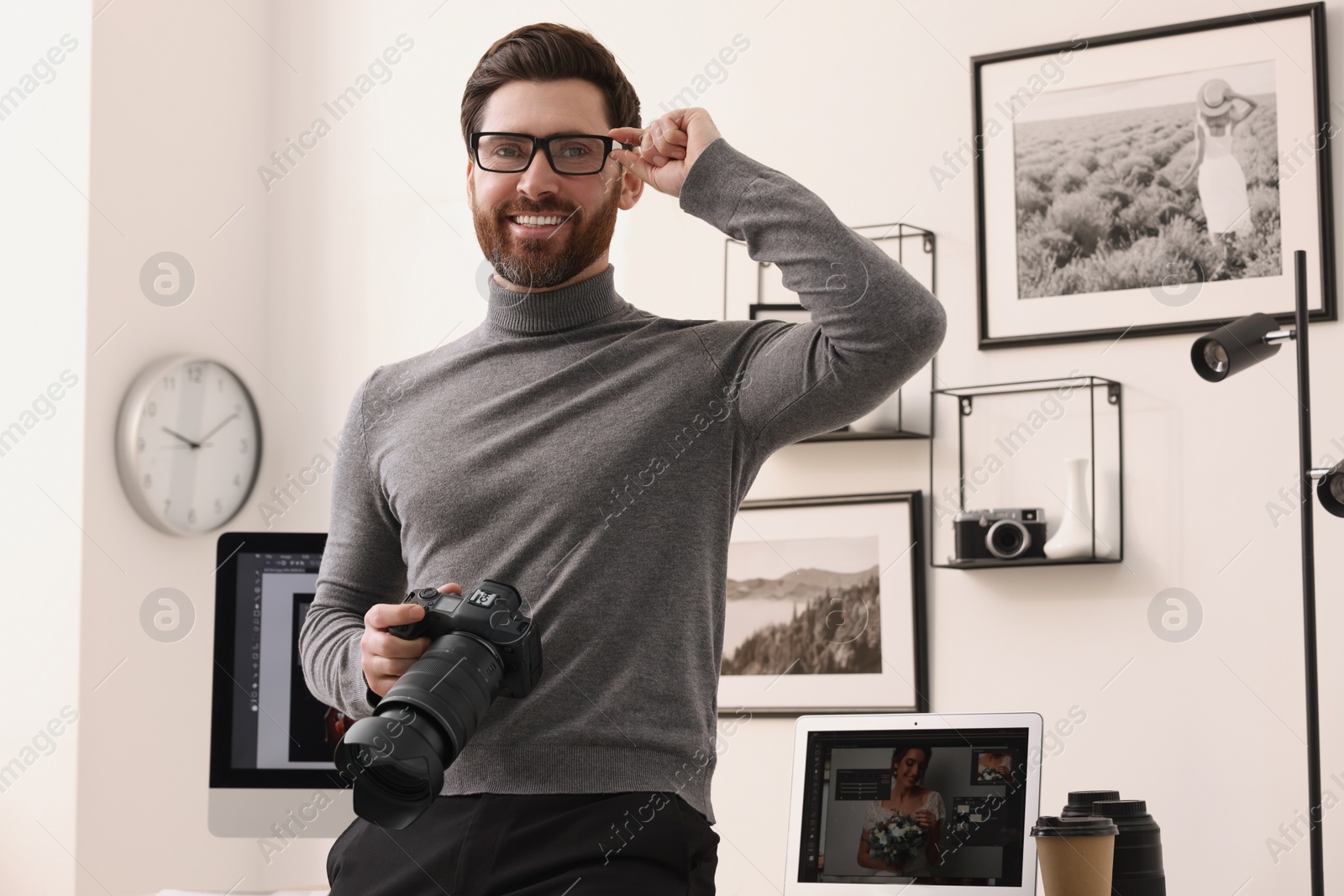 Photo of Professional photographer in glasses with digital camera in office