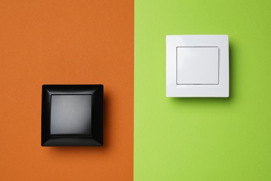 Photo of White light switches on color background, flat lay