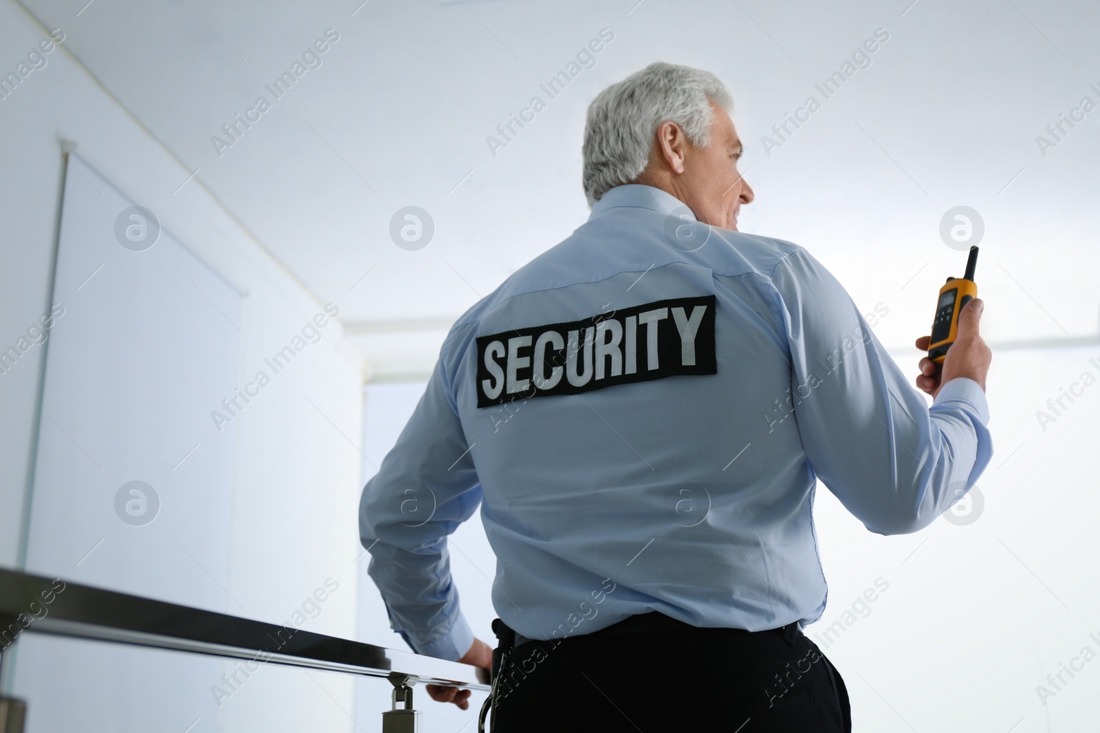 Photo of Professional security guard with portable radio set in office