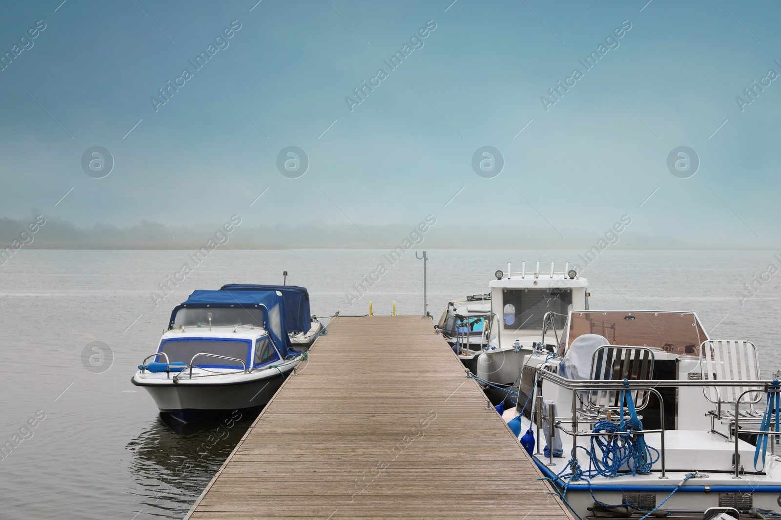 Photo of Picturesque view of wooden pier with moored boats
