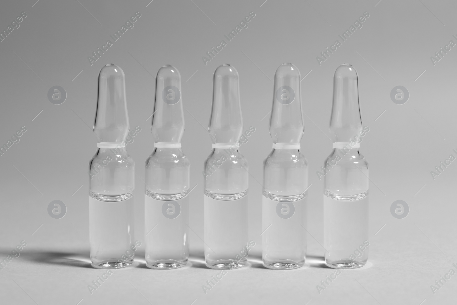 Photo of Pharmaceutical ampoules with medication on light grey background