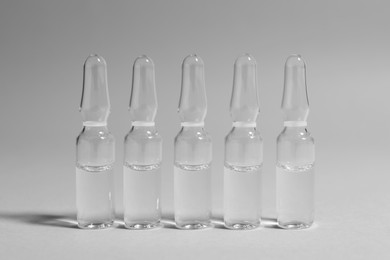 Photo of Pharmaceutical ampoules with medication on light grey background