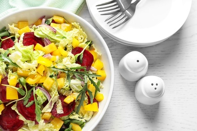 Photo of Bowl with tasty beets salad on table, closeup