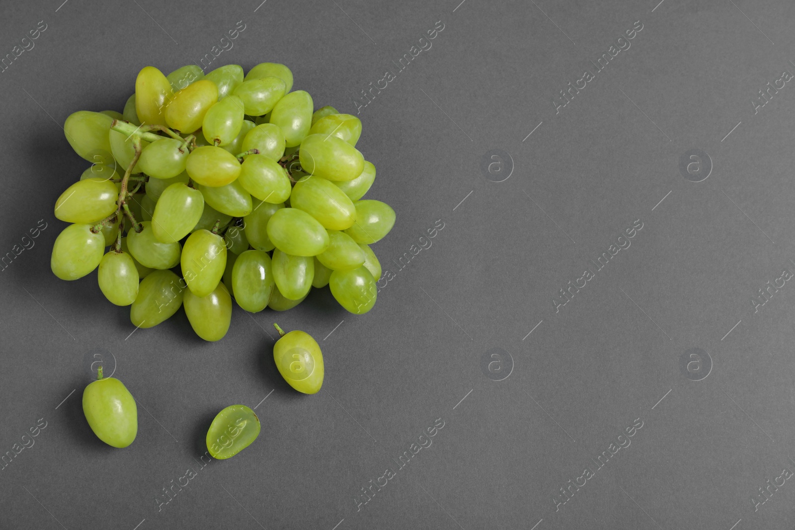 Photo of Fresh ripe juicy grapes on grey background, top view. Space for text