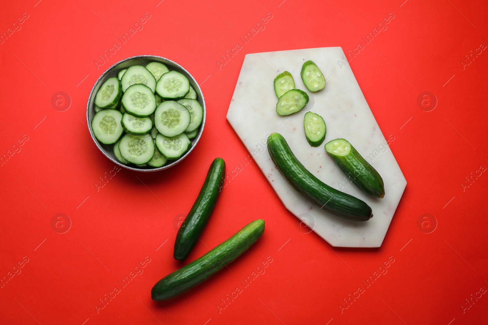 Photo of Fresh ripe cucumbers on red background, flat lay
