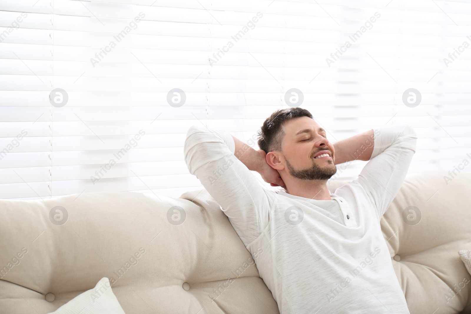 Photo of Handsome man relaxing on sofa, space for text