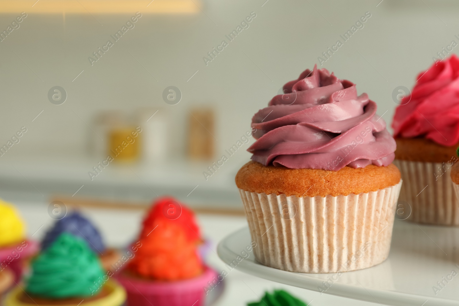 Photo of Delicious cupcakes with colorful cream on stand, closeup. Space for text