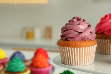 Delicious cupcakes with colorful cream on stand, closeup. Space for text