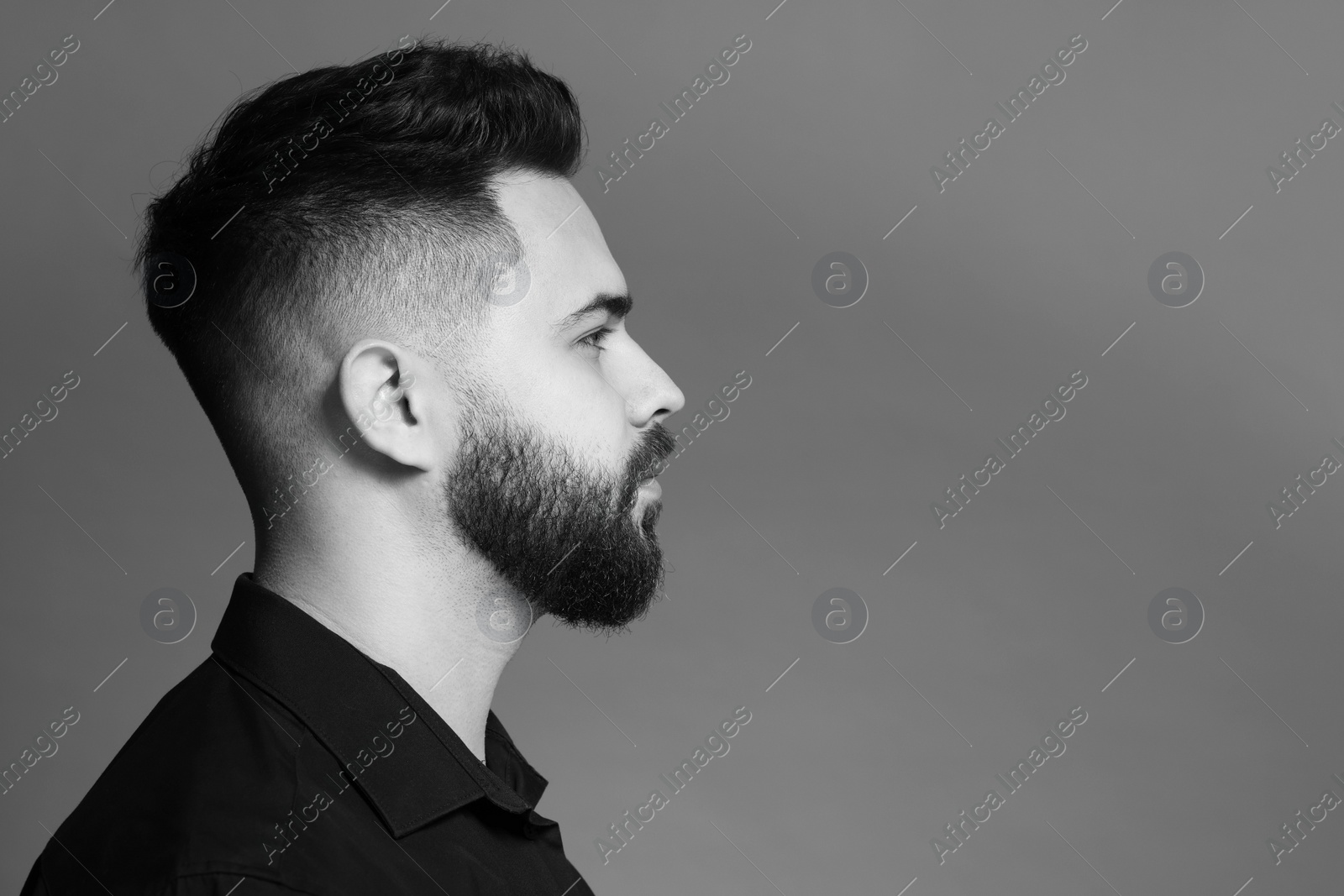 Photo of Portrait of handsome bearded man on grey background, space for text. Black and white effect