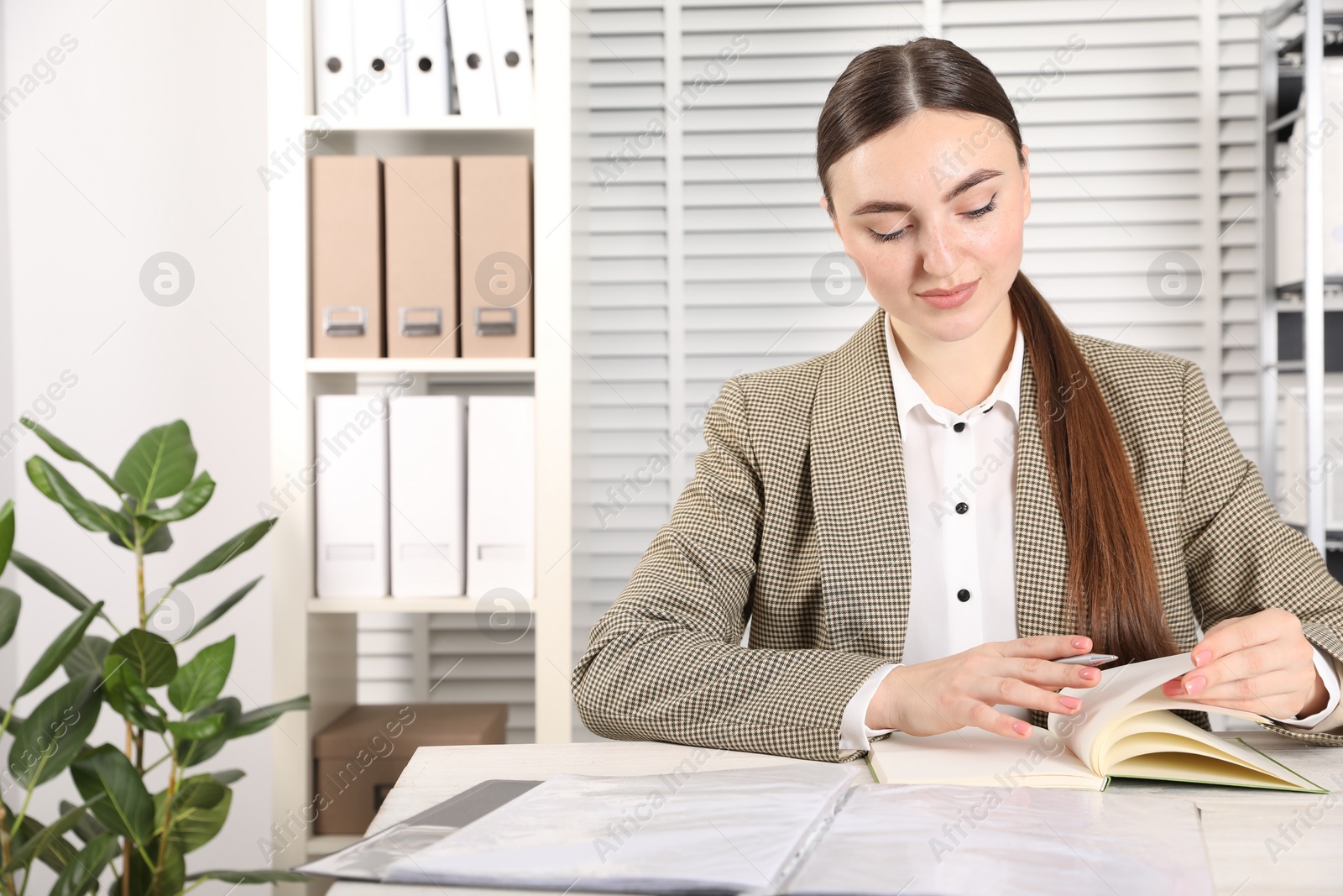 Photo of Woman taking notes at table in office, space for text