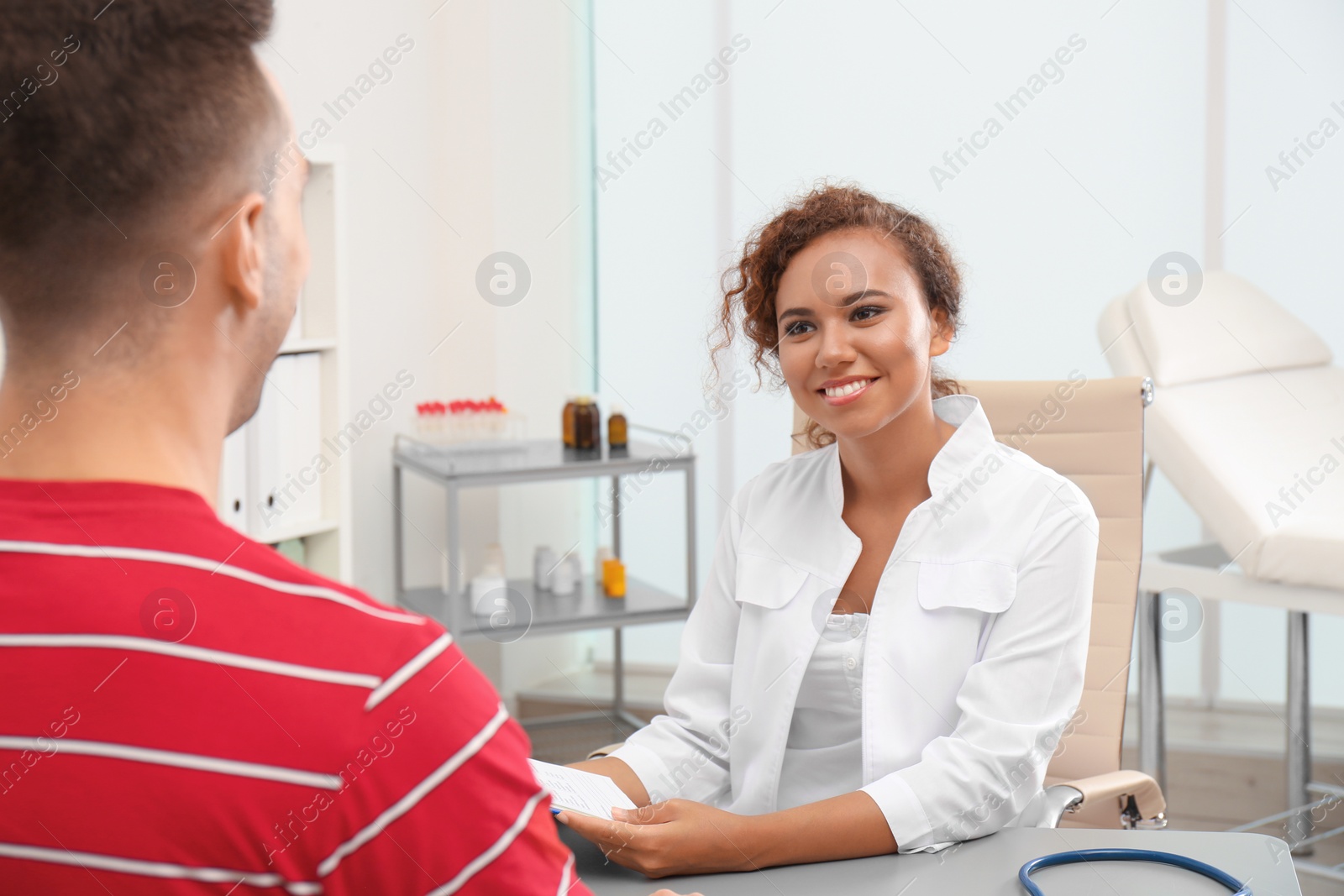 Photo of African American doctor working with patient in hospital