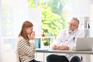 Photo of Coughing teenage girl visiting doctor at clinic