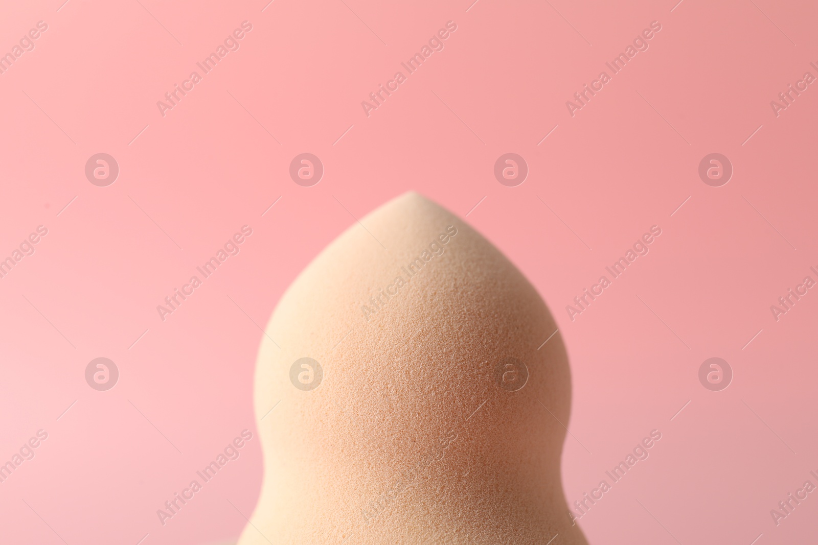 Photo of One makeup sponge on pink background, closeup