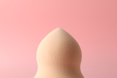 Photo of One makeup sponge on pink background, closeup