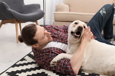 Photo of Adorable yellow labrador retriever with owner at home