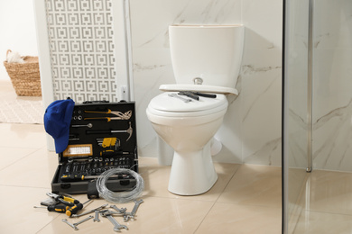 Photo of Plumber's tools near toilet bowl in bathroom
