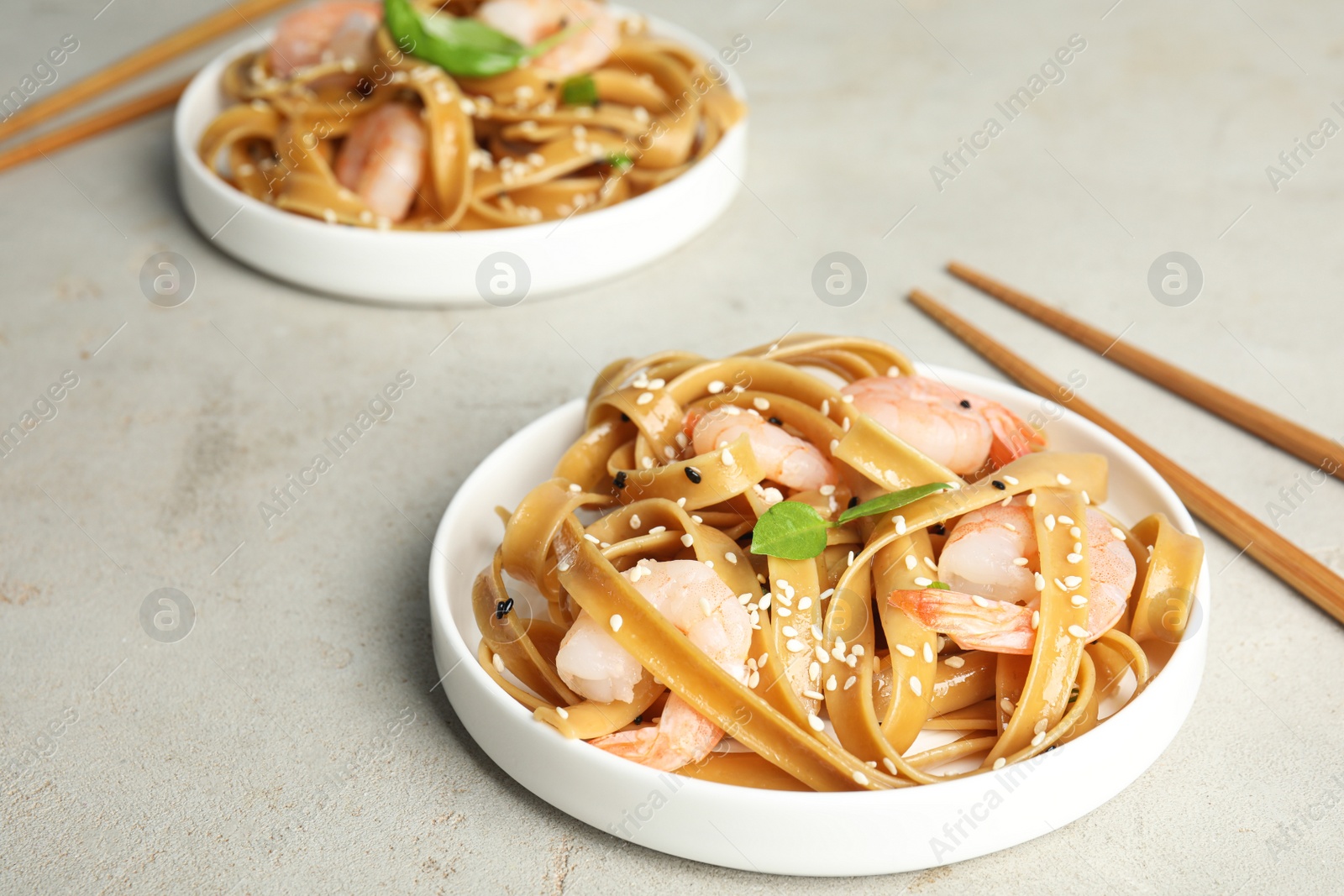 Photo of Tasty buckwheat noodles with shrimps served on light table