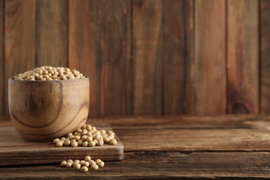 Photo of Soy in bowl on wooden table, space for text